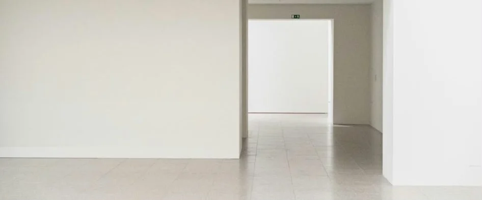 Lichte, lege ruimte met doorkijk naar een volgende kamer